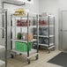 A Cambro Camshelving Elements mobile unit in a school kitchen filled with food.