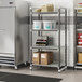 A Cambro Elements XTRA Camshelving unit in a school kitchen with white containers and boxes on it.