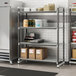 A Cambro metal shelving unit with vented shelves holding brown boxes and containers.