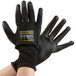 A pair of hands wearing black Cordova Monarch cut-resistant gloves with black polyurethane palm coating.