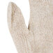 A close up of a medium Cordova beige knit work glove with a thumb.