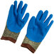 A pair of small Cordova cut-resistant gloves with blue latex palms and camo and brown fabric.