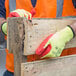 A person wearing a Cordova yellow cut-resistant glove holding a piece of wood.