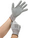 A pair of hands wearing small Cordova HPPE gloves with gray polyurethane palm coating.