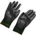 Two black gloves with green trim.