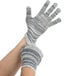 A pair of hands wearing grey and white striped Cordova work gloves.