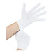 A pair of white polyester and cotton work gloves being worn on hands.