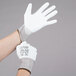 A pair of hands wearing Cordova white gloves with white polyurethane palms.