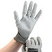 A hand wearing a gray Cordova Monarch engineered fiber work glove with a gray polyurethane palm coating.