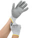 A pair of small hands wearing Cordova cut-resistant work gloves with gray polyurethane palms.