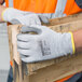 A person wearing Cordova cut-resistant gloves holding a piece of wood.