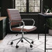 A Martha Stewart brown faux leather swivel office chair at a black desk.