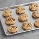 Pre-formed Michael's vegan chocolate chip walnut cookie dough with cookies on a baking sheet.