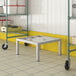 A Regency aluminum dunnage rack on a white tile floor next to a yellow cart.