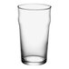 An Acopa Select clear English pub glass full of a clear beverage on a white background.