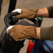 A man wearing Cordova grain cowhide leather driver's gloves on a machine.