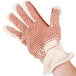 A hand wearing a Cordova hot mill glove with a red dot on the palm.