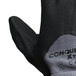 A close-up of a pair of Cordova Conquest Xtra gray warehouse gloves with black foam nitrile and polyurethane palms.