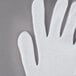 A Cordova white lisle glove on a gray surface.