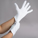 A pair of hands wearing white Cordova inspection gloves.
