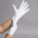 A person wearing white Cordova inspection gloves.