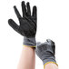 A pair of hands wearing gray and black Cordova Cor-Touch grip gloves.