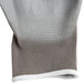 A close up of a gray nylon glove with gray polyurethane coating on the palm.