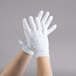 A pair of small hands wearing Cordova Men's white inspector's gloves.