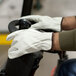 A person wearing Cordova Premium grain cowhide leather driver's gloves while driving a vehicle.