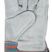 A gray leather Cordova work glove with blue and red stripes on the cuff.