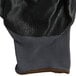 A close up of a gray Cordova glove with black nitrile coating on the palm.