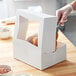 A white auto-popup bakery box with a clear window, designed for cakes, donuts, or pastries.