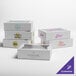 A set of white Baker's Lane bakery boxes with different designs including blue, pink, purple, and yellow text.
