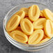 A bowl of Valrhona Passion Fruit couverture feves on a table.