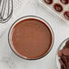 A bowl of liquid chocolate next to a bowl of Republica del Cacao Mexico Dark Chocolate chips.