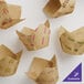 A group of Baker's Lane brown paper tulip baking cups with yellow and green logos.