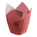 A red Baker's Mark tulip baking cup with gold star designs.