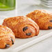 Valrhona dark chocolate batons on a white plate with croissants.