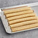 A tray of J & J Snack Foods Hola Churros Chocolate Filled Churros on a gray surface.