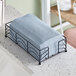 A black metal tray holding indigo Hoffmaster Linen-Like guest towels.