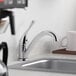 A Delta single handle kitchen faucet on a counter above a sink.
