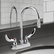 A chrome Delta deck-mount lavatory faucet with two wrist blade handles on a counter.