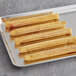 A tray of J & J Snack Foods Hola Strawberry Filled Churros on a gray surface.