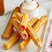 A plate of Hola Churros strawberry filled churros with whipped cream.