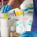 A person pouring Noble Chemical Lemon Lance concentrate into a funnel.