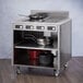 A stainless steel Spring USA induction cooking cart with pans and pots on wheels.