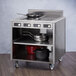 A stainless steel Spring USA mobile induction cooking cart with pots and pans on wheels.