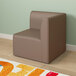 A Flash Furniture neutral vinyl soft seating modular corner chair with a back in a room with wood floors.