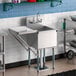A Regency stainless steel 1 compartment sink with faucet and drainboard.