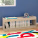 A Flash Furniture wooden shelf with books and toys on it.